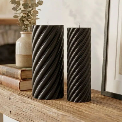 Pillar Candle Set - Two Spiral Columns with twisted black candles displayed on a wooden table.