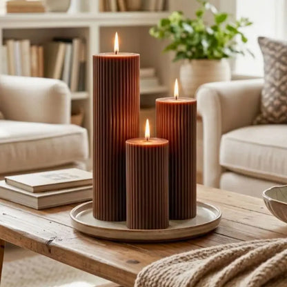 Ribbed Candles - Set of 3 Pillars displayed on a wooden table in a cozy living room.