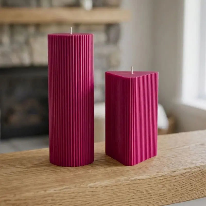 Geometric Pillar Candle set featuring a tall ribbed column and a shorter ribbed triangle in vibrant pink.