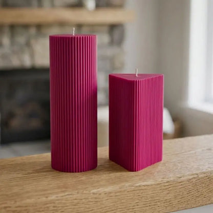 Geometric Pillar Candle set featuring a tall ribbed column and a shorter ribbed triangle in vibrant pink.