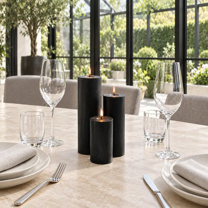 Candles for Dinner - Set of 3 black pillar candles on a dining table with glassware and cutlery.