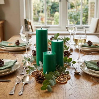Candles for Dinner - Set of 3 green pillar candles on a dining table with festive decor and tableware.