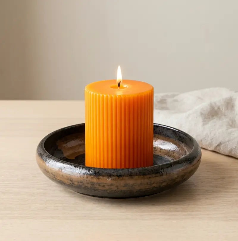 Ceramic Candle Holder with orange candle on a stylish plate enhancing home decor and ambiance.