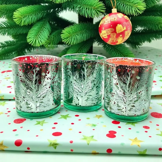 Christmas Candles in decorative glass holders with festive designs, set against a Christmas tree background.