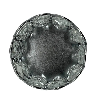 Clear glass candle holder with decorative edge on a white background