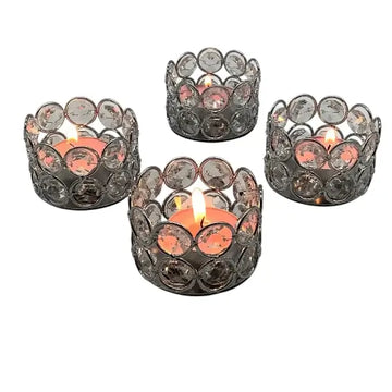 Set of four decorative candle holders with candles on a white background
