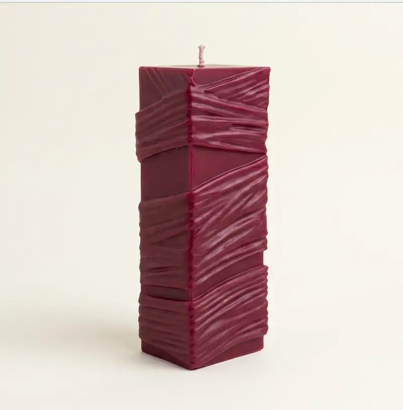 Custom Candle in large sculptural design, hand-poured with a rich burgundy color and textured surface.