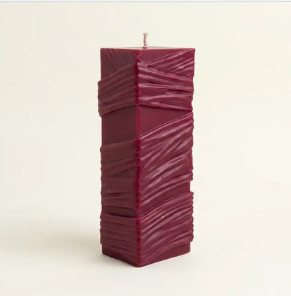 Custom Candle in large sculptural design, hand-poured with a rich burgundy color and textured surface.