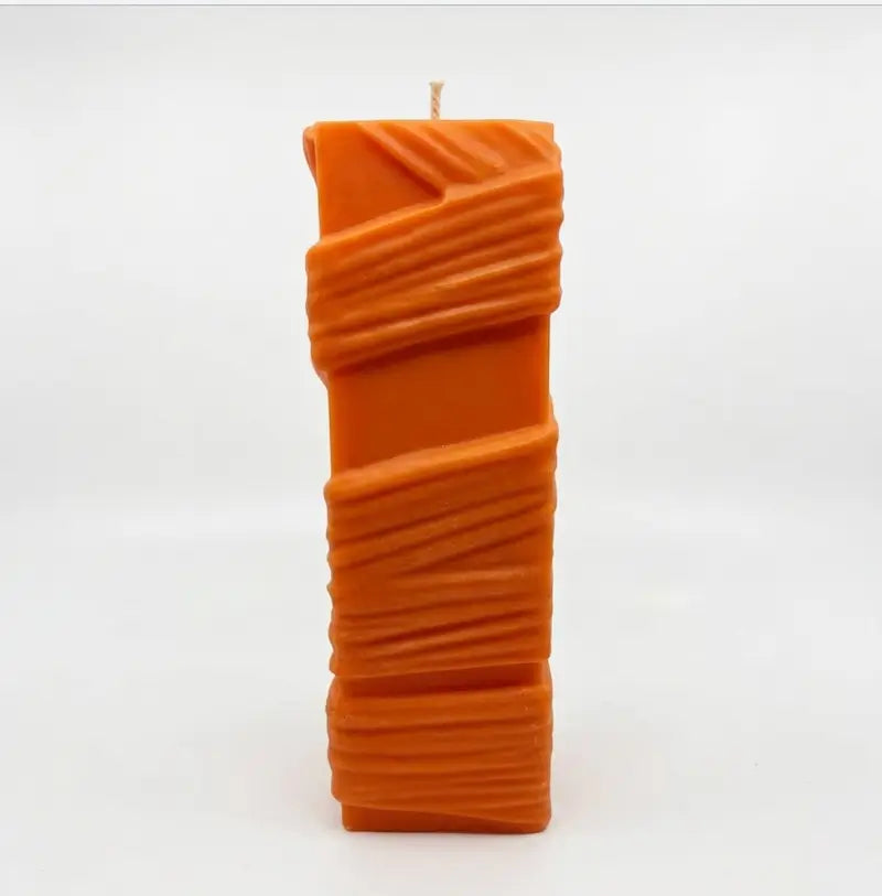 Custom Candle in large sculptural design, hand-poured orange wax with unique textured details.