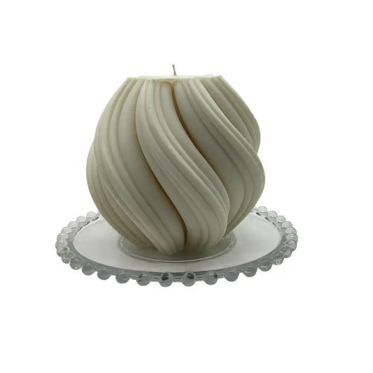 White sculptural candle on a decorative glass candle plate with white background