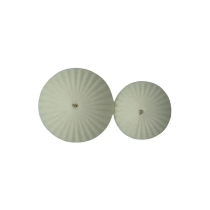Pair of round, floating candles on a white background