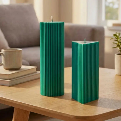 Geometric Pillar Candle Set featuring ribbed triangle and tall ribbed column in green on a wooden table.