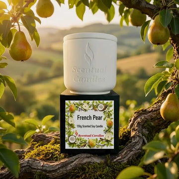 French Pear Candle on a wooden table surrounded by fresh pears and greenery, representing elegance and aroma.