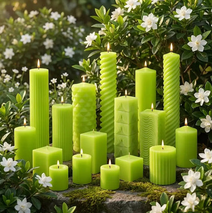 Collection of Gardenia scented green candles with textured surfaces on a stone surface surrounded by white flowers and greenery.