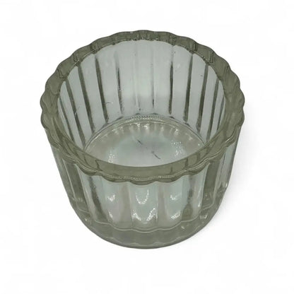 Clear glass candle holder with ribbed design on a white background