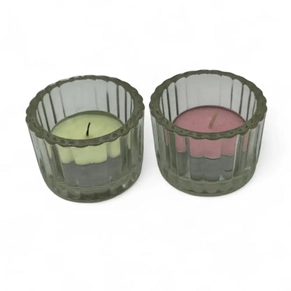 Two candle holders with candles inside on a white background