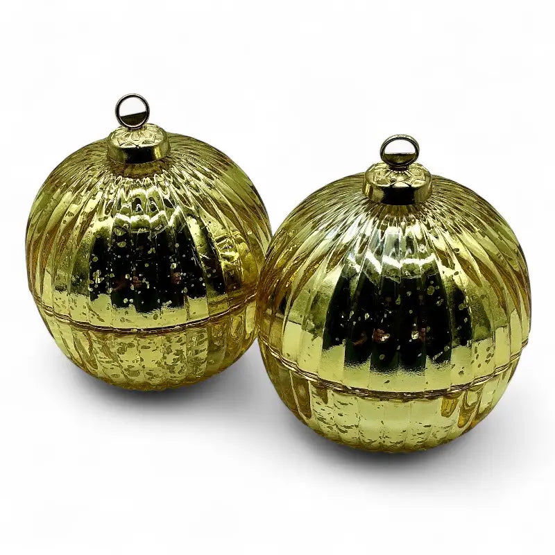 Two gold reflective glass bauble christmas ornaments on a white background