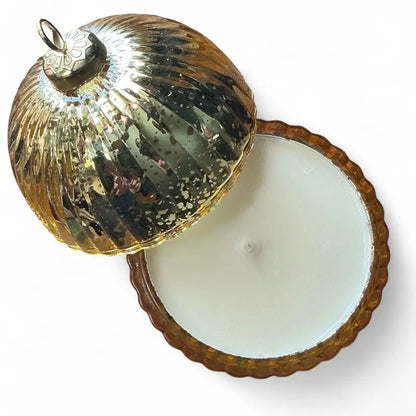 Decorative gold glass bauble candle with a lid on a white background