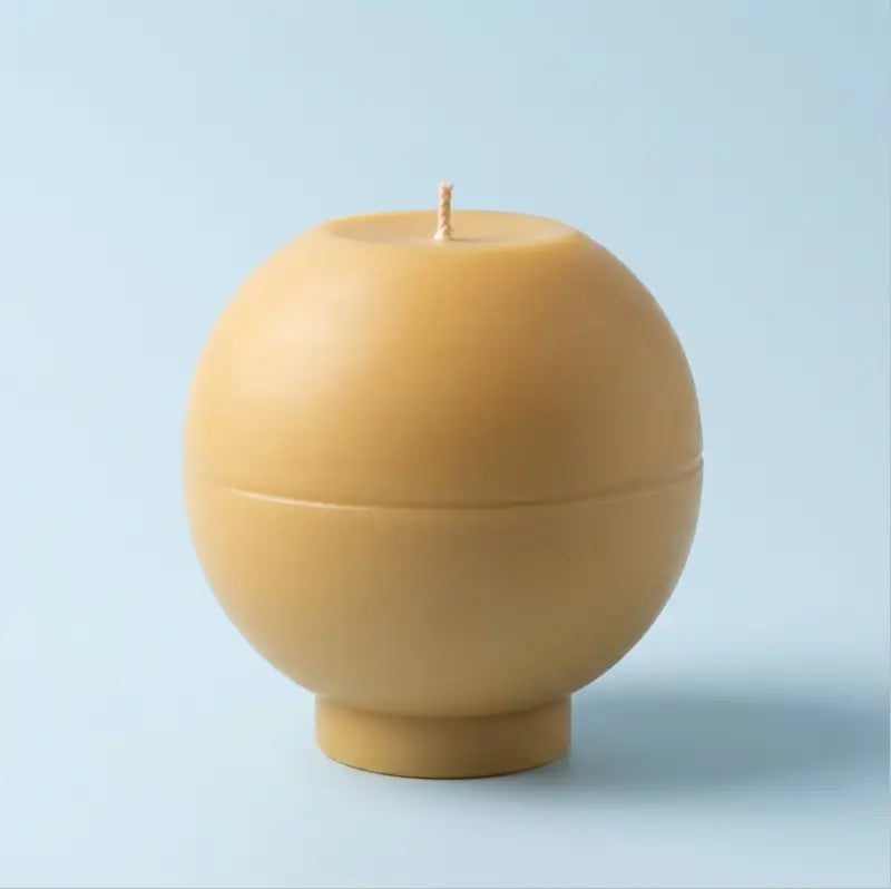 Round Candle in a soft yellow hue, showcasing its sculptural design and oversized shape.