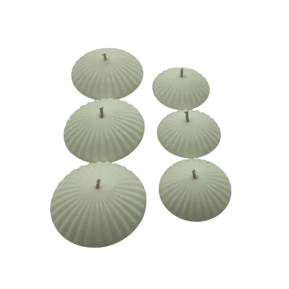 Set of six ribbed floating candles on a white background