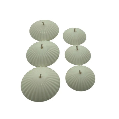 Set of six ribbed floating candles on a white background