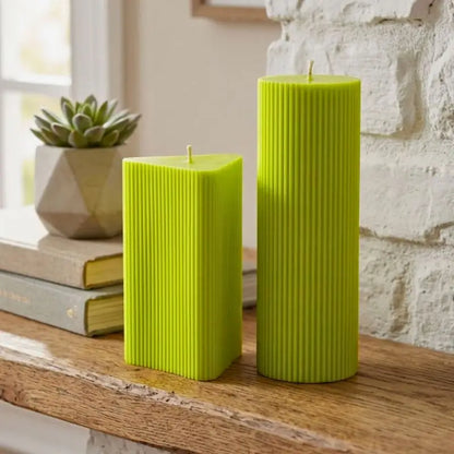 Geometric Pillar Candle Set with vibrant green ribbed candles on a wooden shelf, showcasing unique shapes and textures.