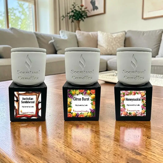 Living Room Scented Candles set with Australian Sandalwood, Citrus Burst, and Honeysuckle fragrances displayed on a wooden table.
