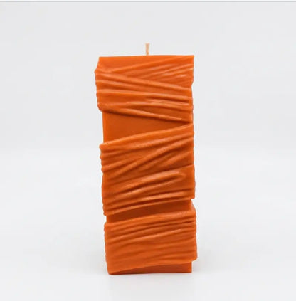 Custom Candle - Large Sculptural Design in vibrant orange color with unique textured pattern.