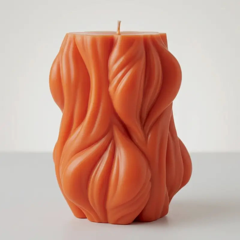 Decorative Candle with unique wave design in orange, adding style and fragrance to any space. Ideal for home decor.
