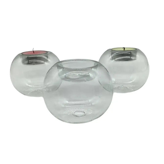 Three clear glass candle holders with red candles on a white background