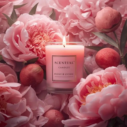 Lychee Scented Candle surrounded by pink peonies and lychee fruit, capturing a blend of floral elegance and juicy sweetness.