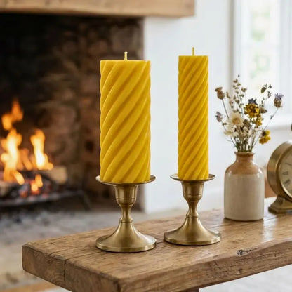 Pillar Candle Set featuring two spiral columns, one tall and sculptural, the other slim, on a rustic table.