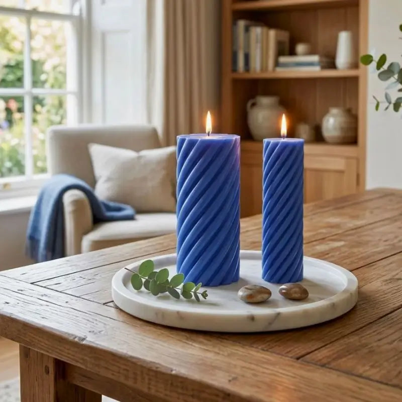Pillar Candle Set featuring two spiral columns in blue on a marble tray, creating a cozy atmosphere.