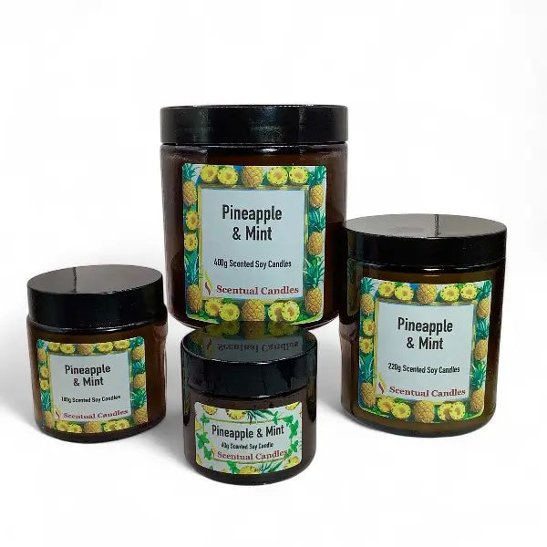 Four scented candles labeled 'Pineapple & Mint' on a white background