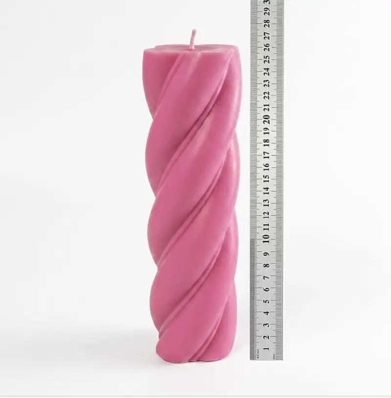 Extra large pink Customisable Candle with a twist design, showcasing its height next to a ruler.