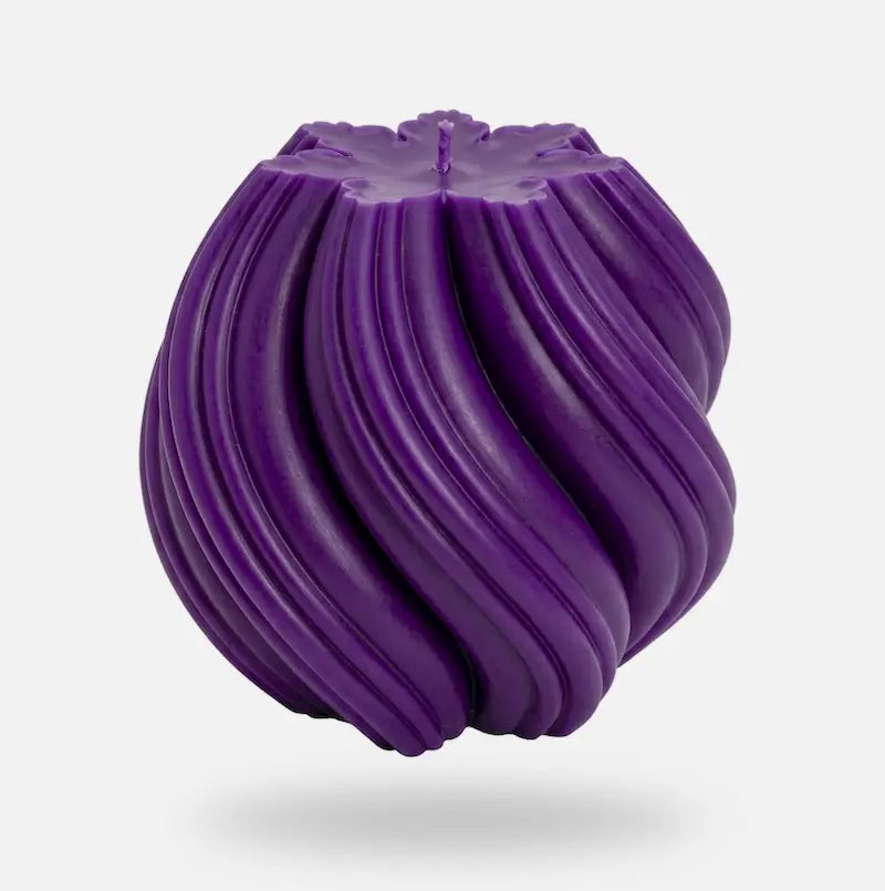 Ball Candle in a bold purple color featuring a sculptural design with flowing grooves