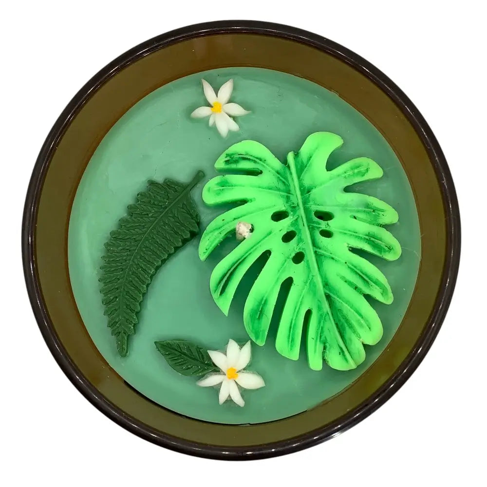 Decorative scented candles top with green leaves and white flowers on a green background