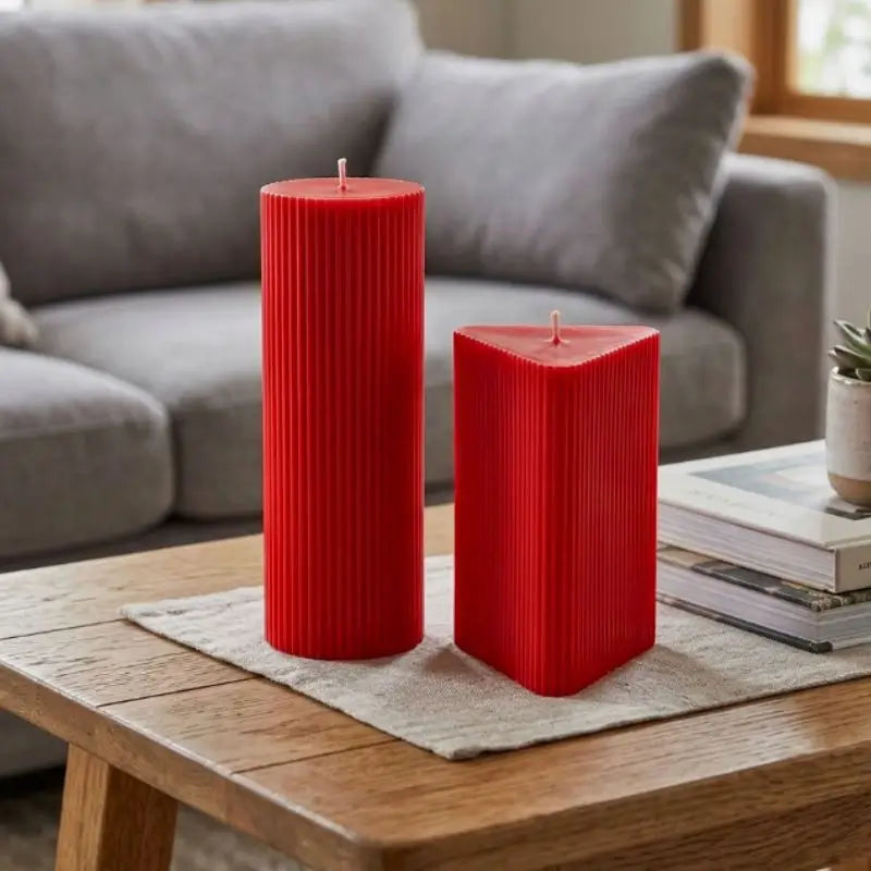Geometric Pillar Candle Set featuring ribbed red triangle and tall column on a wooden table.