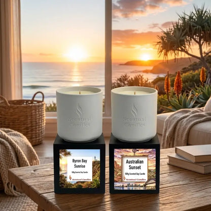 Sunrise and Sunset Australian Scented Candle Duo displayed by a window overlooking the beach during sunset.