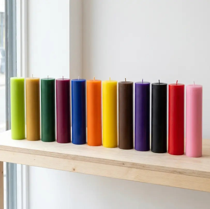 Collection of vibrant Tall Candles in various colors on a shelf, showcasing height and elegance.