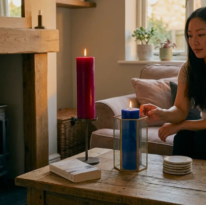 Tall Candle in purple and blue on a table, enhancing the cozy living room atmosphere with warmth and elegance.