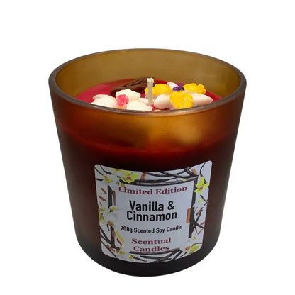 Vanilla & Cinnamon scented candles with decorative elements in a brown glass container on a white background.