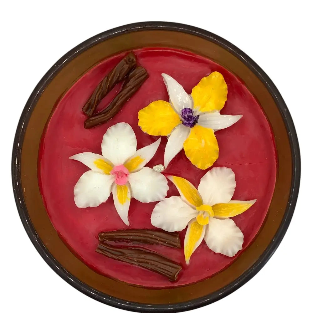 Decorative scented candles top with flowers and cinnamon sticks on a red background