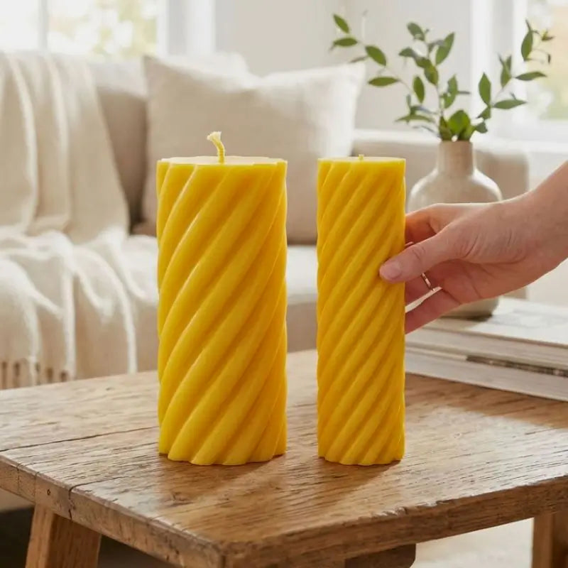 Pillar Candle Set featuring two yellow spiral column candles on a wooden table in a cozy living space.