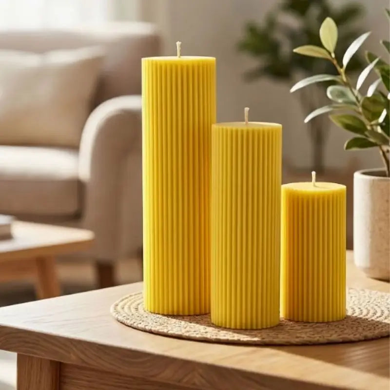 Ribbed Candles - Set of 3 Pillars in yellow, showcasing clean ribbing and varying heights on a table.