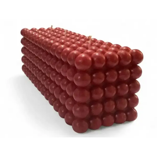 Red cube-shaped bubble candle made of small spheres on a white background