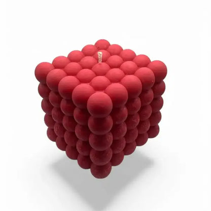 Red cube-shaped bubble candle made of spherical sections on a white background