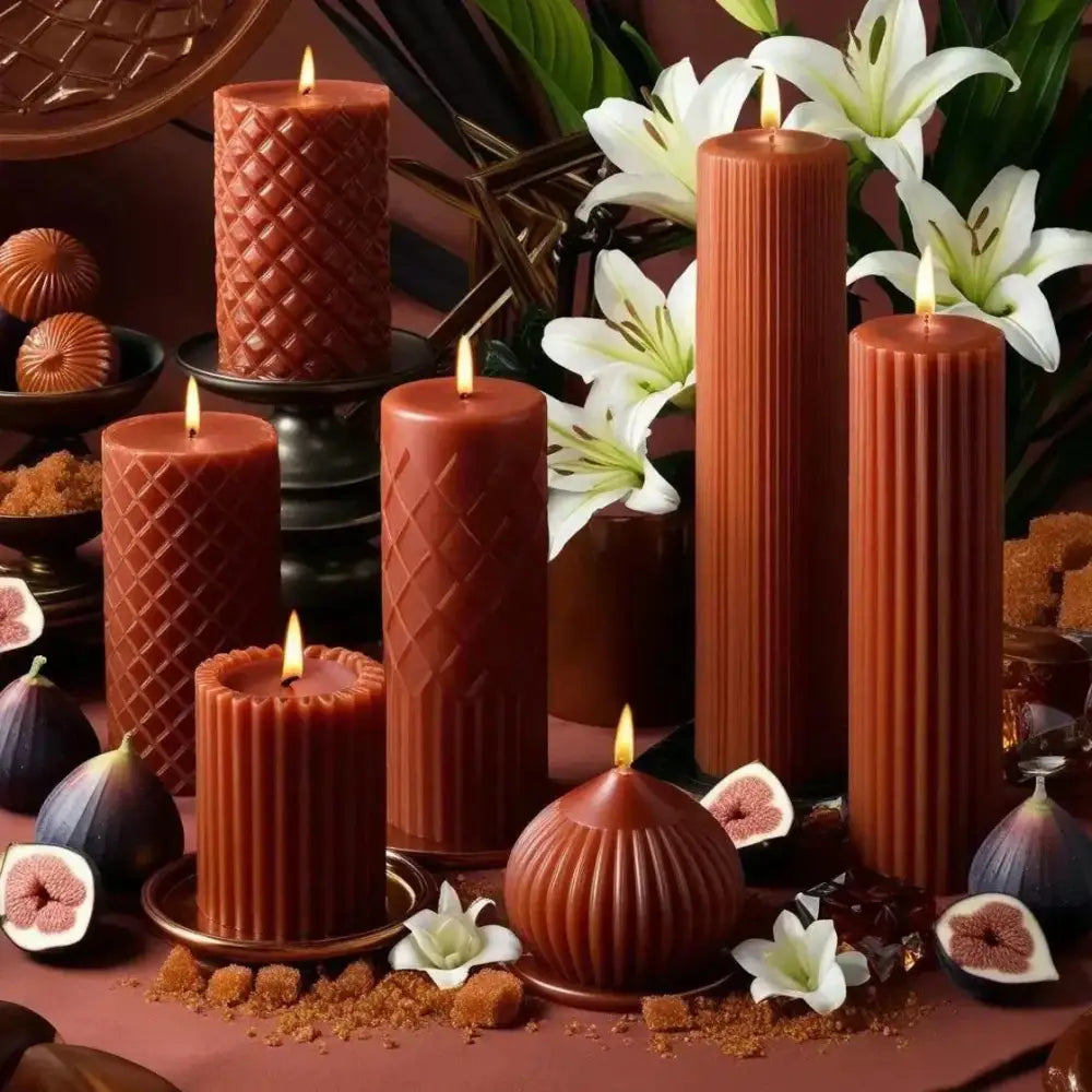 Caramelised Fig Scented Soy Pillar Candles with architectural designs, surrounded by figs and lilies, creating a warm autumn ambiance.