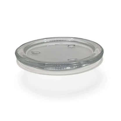 Round transparent glass candle holder plate with small feet for stability.