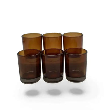 Set of six brown glass votive candle holder on a white background